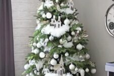 16 a whimsical neutral Christmas tree with white and silver ornaments, white faux fur garlands, berries, branches, houses and a snowflake tree topper