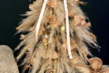17 a tabletop pampas grass Christmas tree, embellished with leafy twigs and grain sprigs and some lights is a chic idea