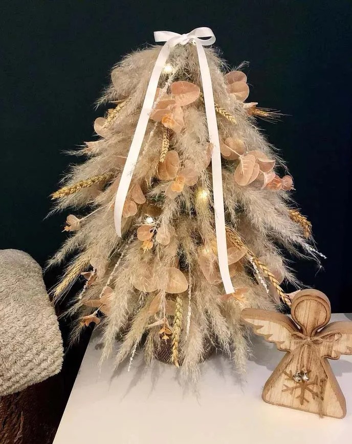 a tabletop pampas grass Christmas tree, embellished with leafy twigs and grain sprigs and some lights is a chic idea