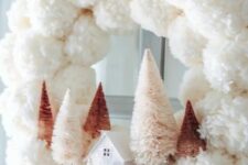18 a delicate white pompom Christmas wreath with blush and rustic bottle brush trees and a mini house plus a mauve bow