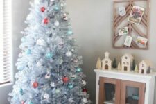 19 a vintage silver Christmas tree with blue, white and red ornaments and stacks of gift boxes and deer is a beautiful and refined idea