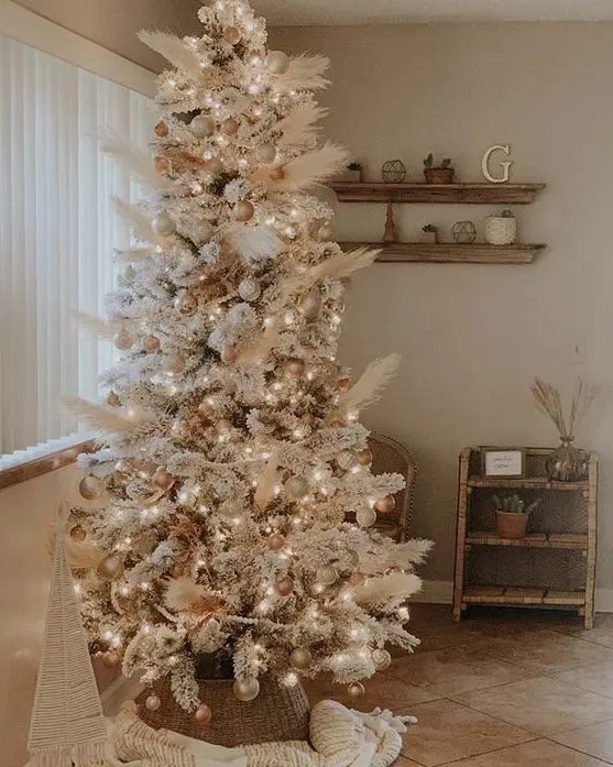 an amazing neutral boho Christmas tree decorated with pampas grass, gold and metallic ornaments, white ones and lights