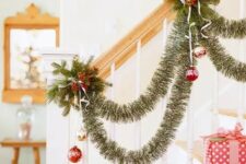 19 an elegant tinsel garland with gold and red ornaments, evergreens and berries are a nice combo for Christmas decor