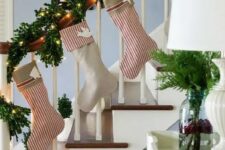 20 an evergreen and lights Christmas garland that wraps the banister and striped stockings are great decor for a banister