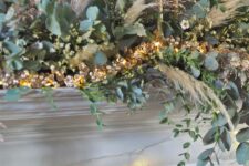 21 a super lush Christmas mantel garland of greenery, lights and pampas grass plus tall and thin candles is amazing