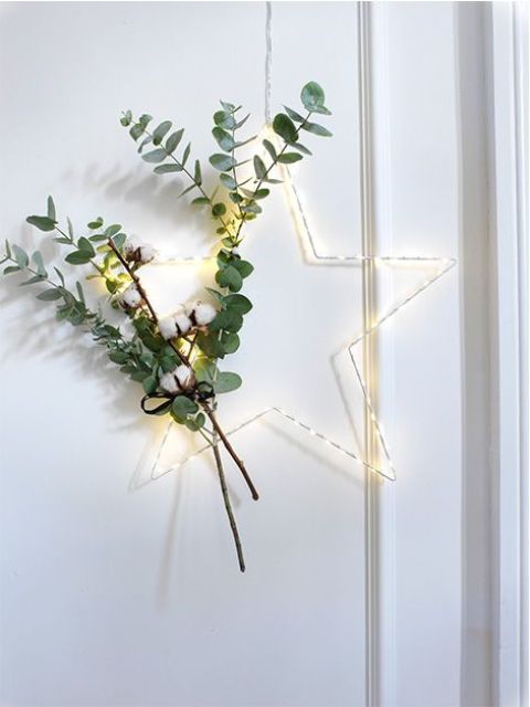 a lit up Christmas wreath with cotton and eucalyptus is a lovely decor idea for a Scandi or modern space