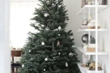 22 a minimalist Christmas tree dotted with clear and white ornaments and covered with white fabric at the base is fresh and cool