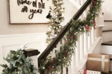 22 an evergreen Christmas garland with berries and lights, a matching wreath with gold ornaments for banister decor