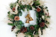24 a Christmas wreath of evergreens, pampas grass, pinecones, bells and a large neutral bow is a chic idea