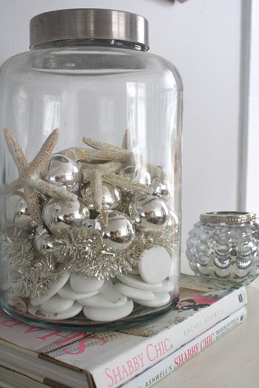 a large jar with silver ornaments and silver tinsel, with starfish and shells is a lovely decor idea for coastal Christmas