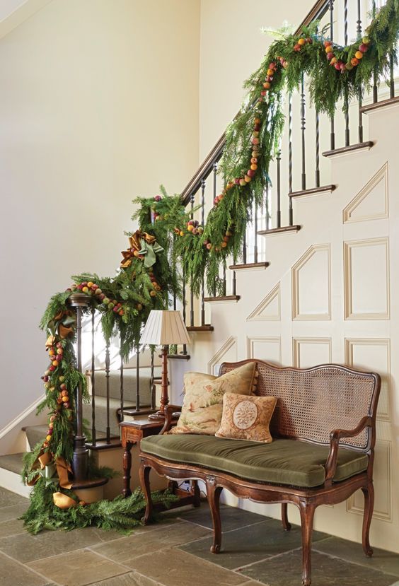 an evergreen Christmas garland with colorful pompoms and ribbons is a natural and pretty idea to rock