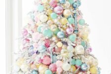 25 a flocked Christmas tree decorated with candy-colored ornaments that cover the whole tree