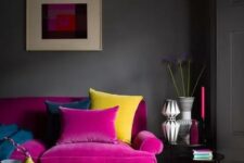 25 a moody living room with grey walls, a magenta sofa, a yellow tufted ottoman, a printed rug, chic vases and candles