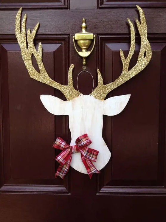 a deer silhouette door hanger with glitter antlers and a plaid bow is an elegant and cool Christmas decoration for a front door