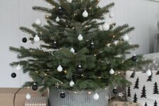 26 a minimalist Scandi Christmas tree placed into a planter, with small black and white ornaments and LED lights