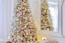 27 a flocked Christmas tree with metallic and pastel ornaments plus lights looks chic and soft