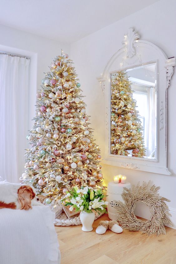 a flocked Christmas tree with metallic and pastel ornaments plus lights looks chic and soft
