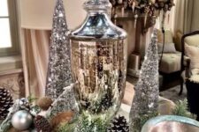 27 a silver Christmas centerpiece of evergreens, pinecones, silver ornaments, silver sequin cone trees and a mercury glass jar