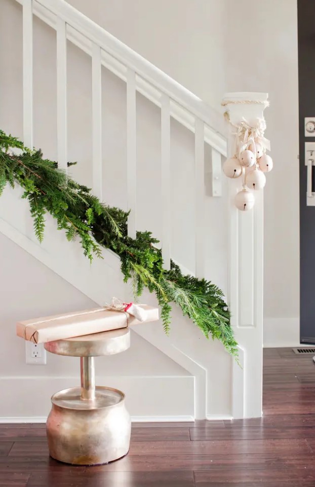 an evergreen garland on the bottom of your banister and white bells attached are a lovely last-minute combo for Christmas