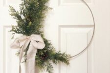 29 a modern Christmas wreath with evergreens and pinecones on one side and a neutral ribbon bow is a lovely decor idea