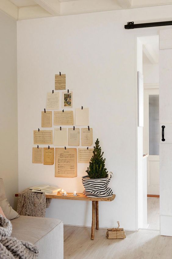 a pretty and easy Christmas wall decoration of vintage cards and book pages shaping a tree on the wall is super creative