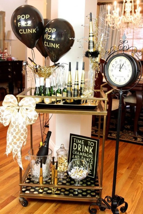 a gold and black bar cart with balloons, a polka dot bow and polka dot paper is ideal for a NYE party