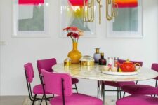 30 a sophisticated living room wiht a gallery wall, a round table, magenta chairs, a beautiful gold chandelier over the table