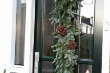 30 a super lush evergreen Christmas garland with pinecones is a lovely decoration for your front door, and it’s easy to DIY