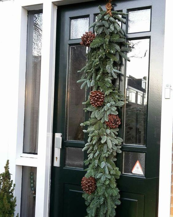 a super lush evergreen Christmas garland with pinecones is a lovely decoration for your front door, and it's easy to DIY