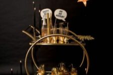 31 a gold bar cart with black candles, gold ornaments, a gold star hanging over it and some gilded leaves is great for NYE