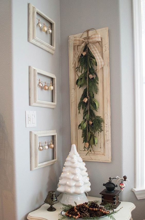 Christmas wall decor with empty frames with ornaments and a sign with an evergreen sawg and bells is a great idea