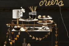 33 a simple black bar cart decorated with a gold foil triangle garland and a neon sign is a great idea for a NYE party