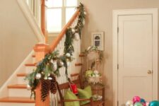 34 an evergreen garland with silver ornaments, lights and pinecones is a lovely decoration for railings at Christmas