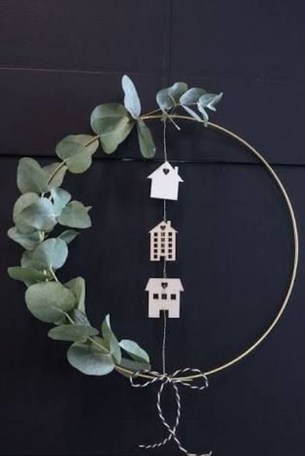 a modern meets Scandinavian Christmas wreath with eucalyptus, plywood houses and an embroidery hoop is wow