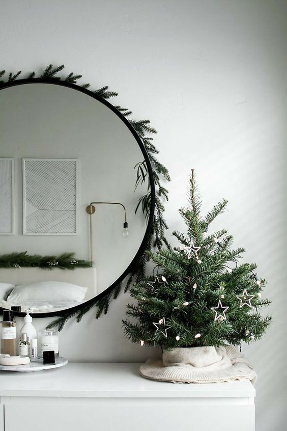a small and minimalist tabletop Christmas tree decorated with lights and star ornaments is a stylish and cool idea