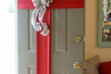 37 a front door styled as a Christmas gift box, with red ribbon and a large bow, looks cute