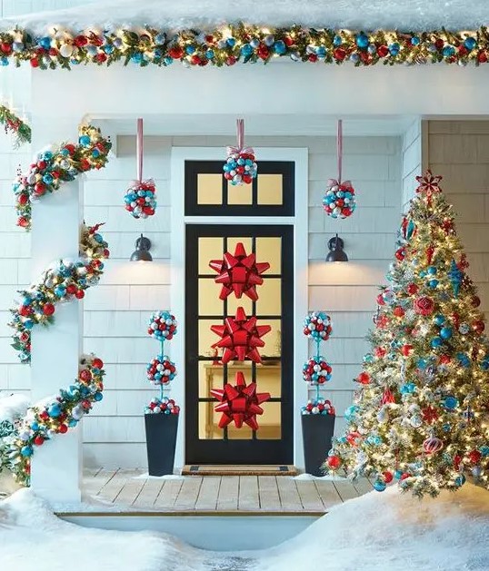 ornament topiaries hanging over the door, garlands and red bows on the door are amazing for styling for Christmas
