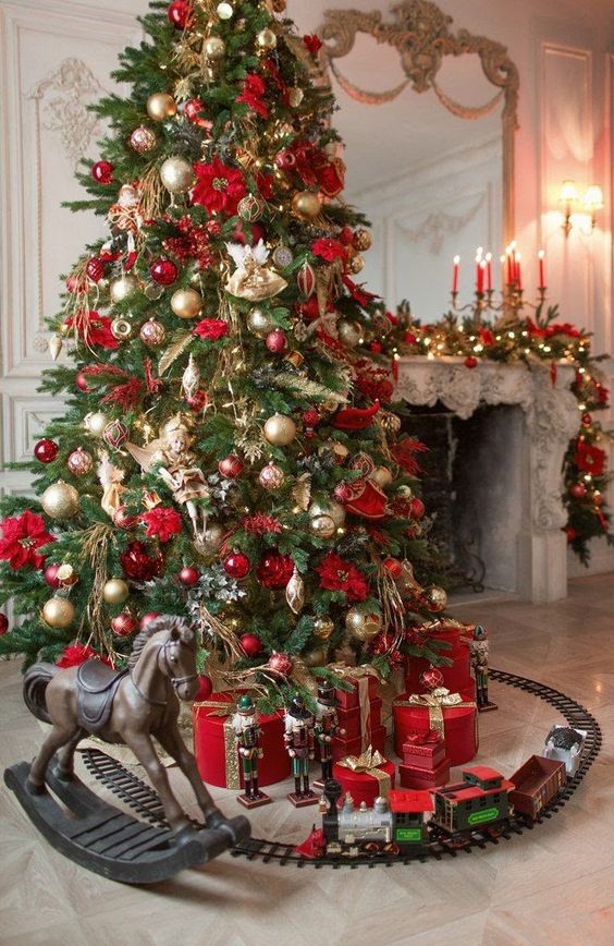 a sophisticated Christmas tree with gold and red ornaments, leaves, branches, ribbons and flowers is wow