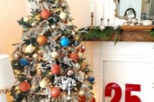 42 a flocked Christmas tree decorated with creamy, copper, rust, blue and gold ornaments, branches and twigs, greenery and a star topper