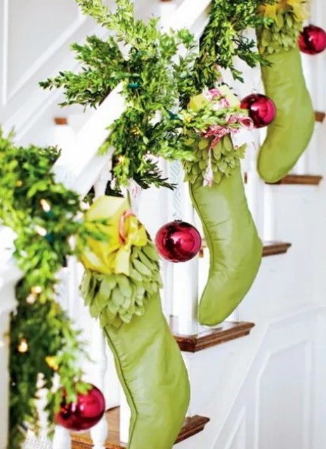 evergreens, green stockings, red ornaments are an amazing colorful combo for your Christmas banister