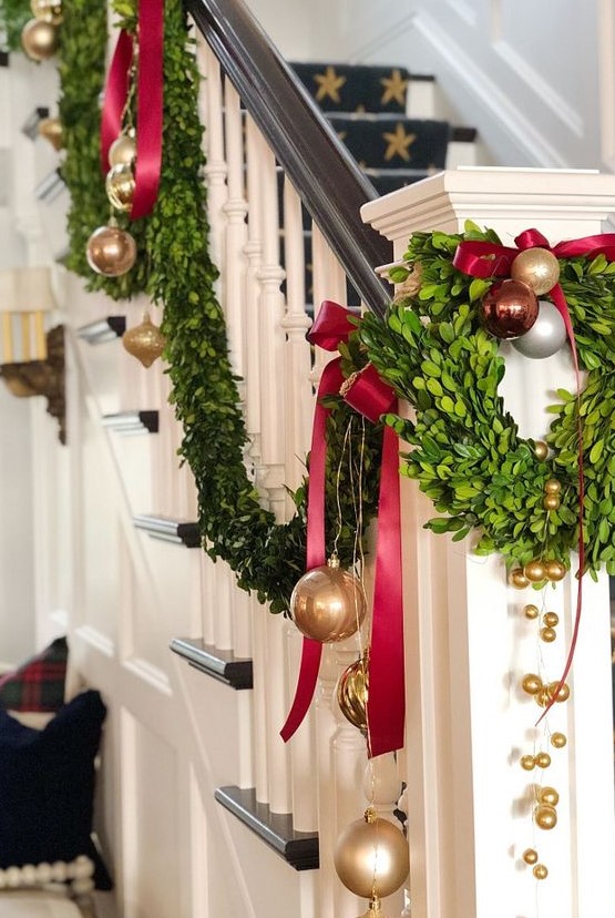 gold, red and brown ornaments, evergreens and deep red bows for decorating the railing for Christmas