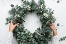 45 a stylish modern Christmas wreath of evergreens, eucalyptus and baby’s breath is a beautiful and textural idea