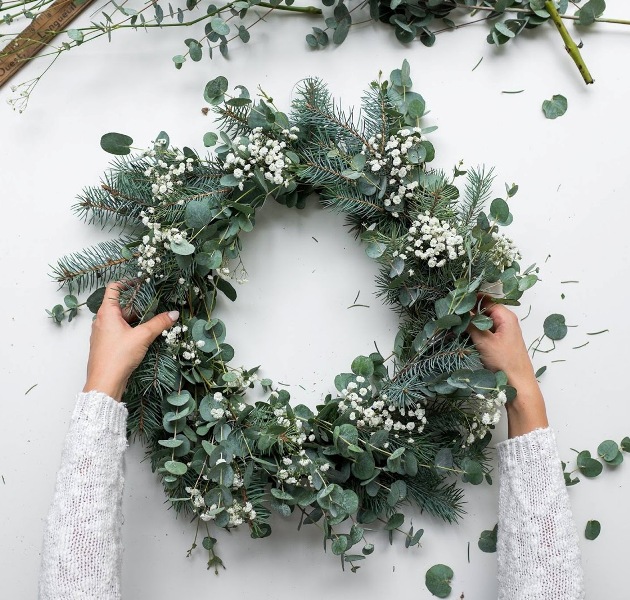 a stylish modern Christmas wreath of evergreens, eucalyptus and baby's breath is a beautiful and textural idea