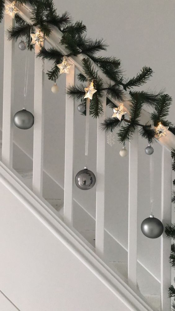 grey and white Christmas ornaments, evergreens and a star-shaped garland are an amazing combo for Christmas decor
