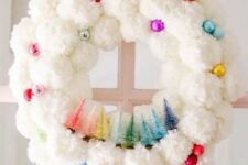 47 a white pompom Christmas wreat decorated with colorful ornaments and colorful bottle brush Christmas trees