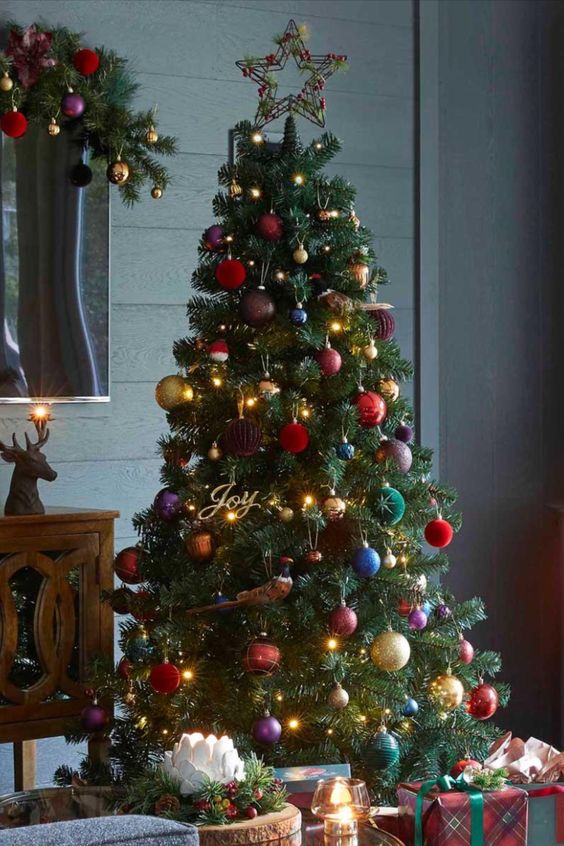 an adorable Christmas tree styled with lights and jewel tone and metallic ornaments, a star topper and calligraphy