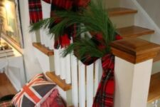 48 pretty Christmas decor with evergreens and plaid scarves on the railing, a plaid bench with plaid pillows is very cozy