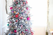 50 a flocked Christmas tree decorated with colorful vintage ornaments and topped with a star is wow