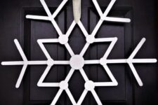 51 an oversized white snowflake Christmas wreath is a creative idea that will make your front door stand out a lot