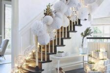 54 usual and gilded leaves paired with white paper pompoms are an amazing idea for Christmas banister decor, add lights to the steps